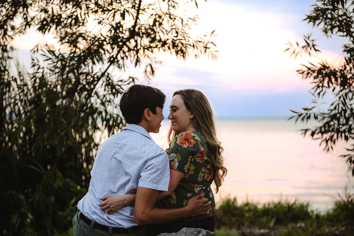 Gary and Natalie looking into each others eyes in front of a lake.