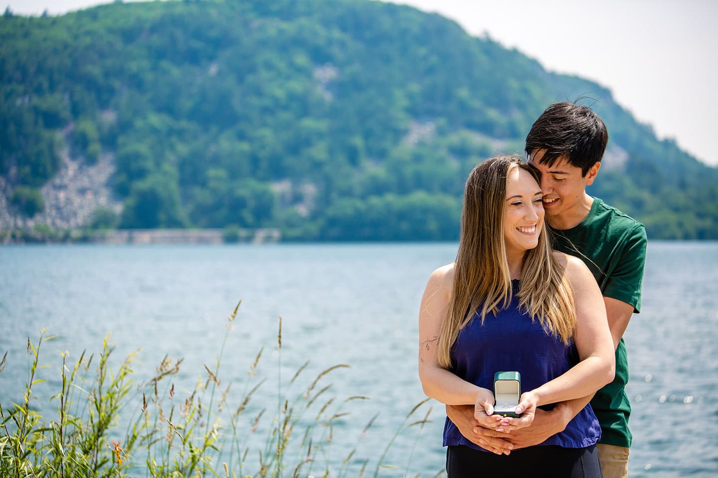 Gary and Natalie embracing in front of a lake. Natalie is holding her wedding ring.